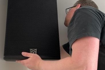 An engineer installing a Martin Audio Blackline speaker.