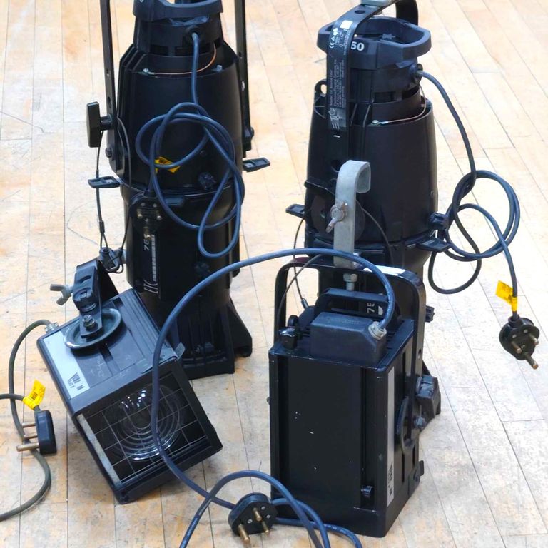 Two 650 watt stage lighting Fresnels with two ETC Source 4 profiles behind. 